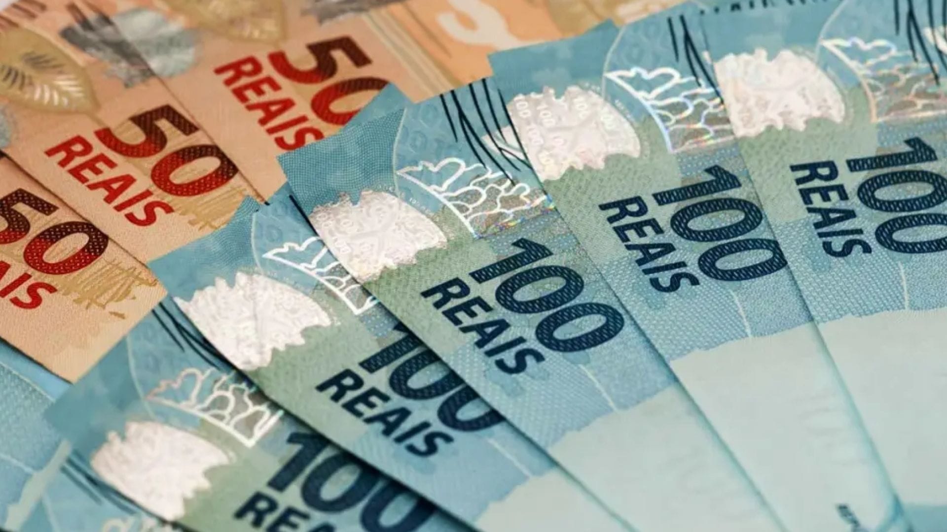 Notas de dinheiro em reais organizadas sobre uma superfície clara